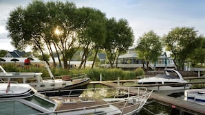 A marina with boats docked, surrounded by trees and a building with a blue roof.