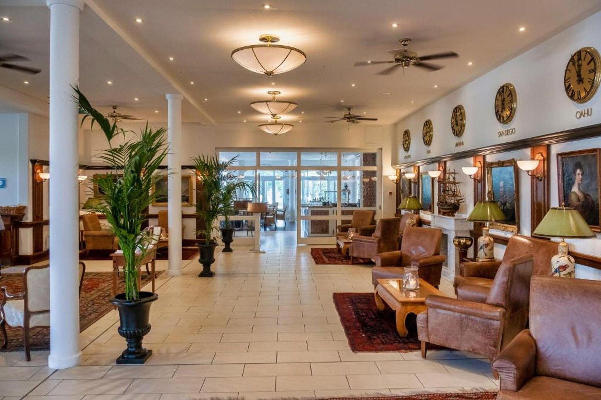 A spacious lobby with a high ceiling, multiple seating areas, and a view into the dining area.