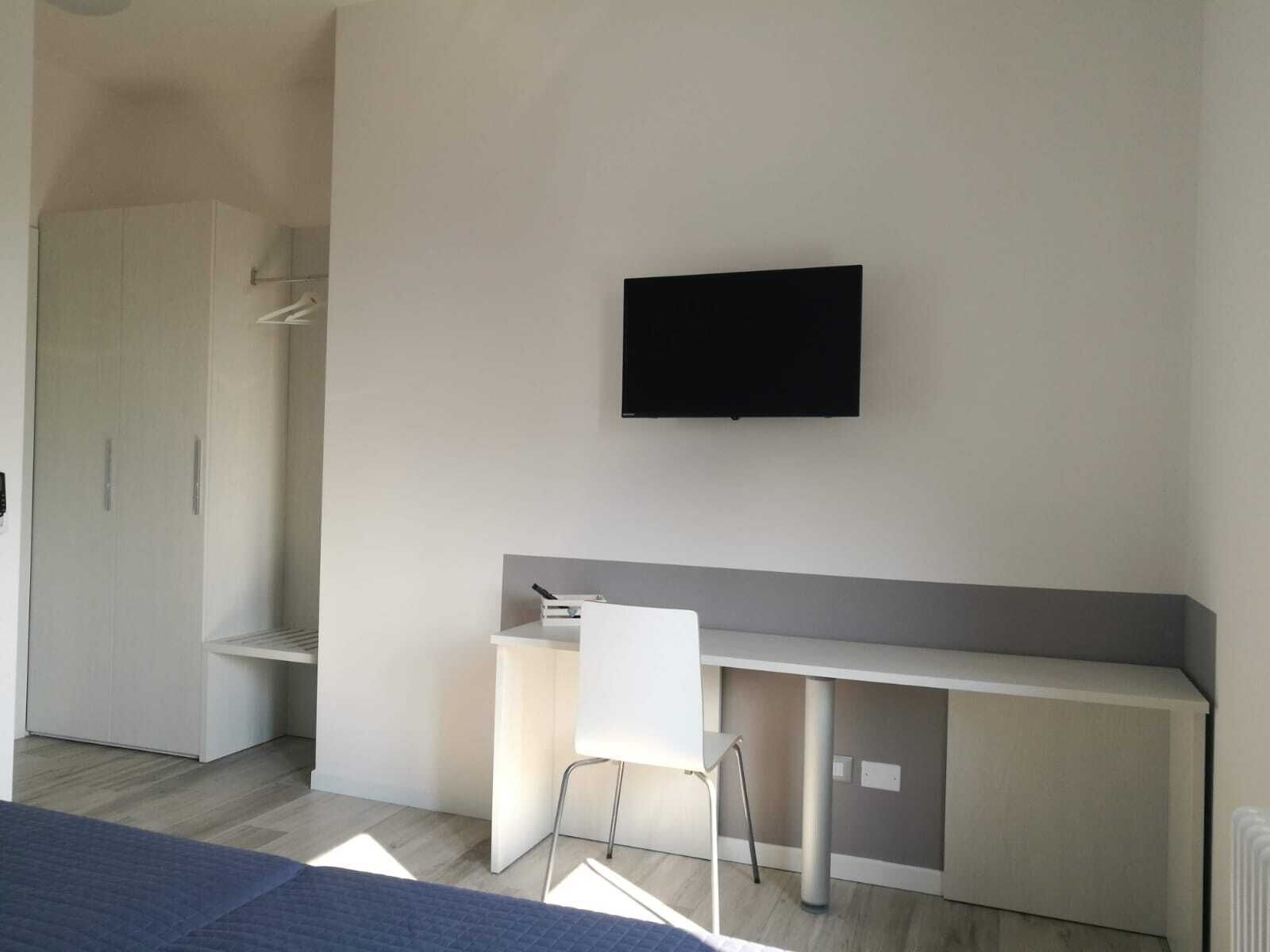 Une chambre à coucher moderne avec un lit, un bureau et une chaise.