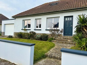 A residential house with a white exterior, a dark blue door, and a tiled roof. - House with garden, 400m from the beach, all on foot, private parking (Wimereux)