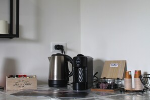 Un coin café équipé d’une machine à café, d’une bouilloire et d’un panneau indiquant qu’il s’agit d’un espace dédié au café.