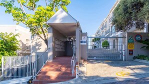 A gated entrance with a metal fence, a red brick staircase, and a clear sky. - Casa del Mar: Sparkling secure 2BR, Wi-Fi, parking (Cape Town)