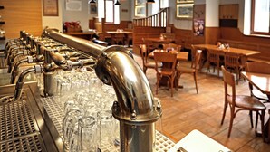 A bar area with multiple taps and glasses, wooden furniture, and pendant lighting. - Pension U Tří sedláků (České Budějovice)