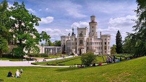A castle-like building with a central tower, surrounded by manicured lawns and pathways. - Pension U Tří sedláků (České Budějovice)