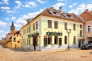 A building with a sign 'U TRI SEDLÁKÚ' and a bicycle parked outside. - Pension U Tří sedláků (České Budějovice)