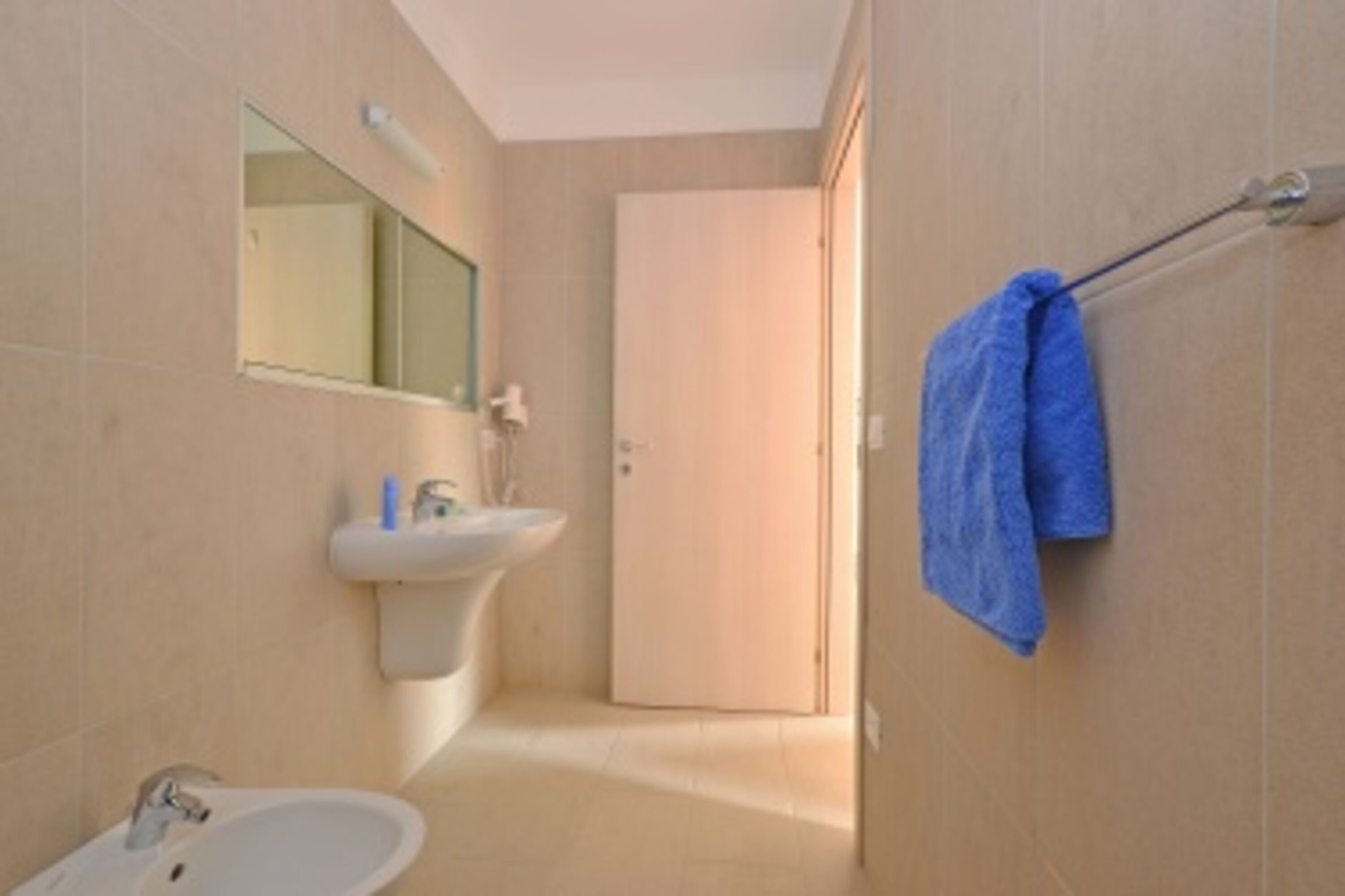 A bathroom with a sink, mirror, and towel rack.