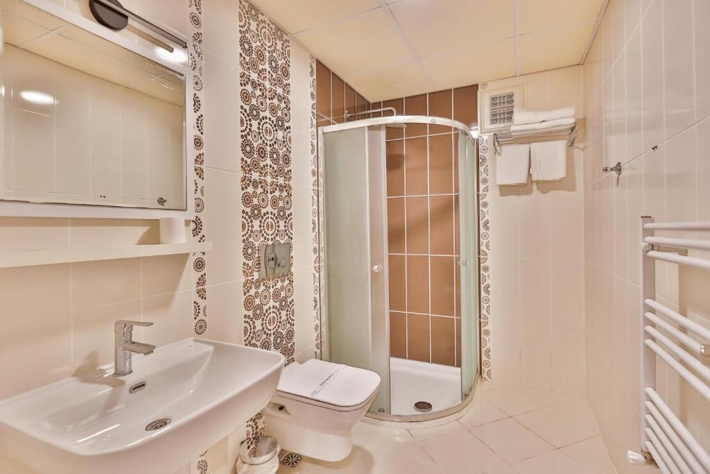 A bathroom with a sink, toilet, and shower.