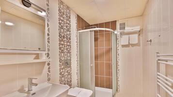 A bathroom with a sink, toilet, and shower.