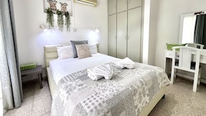 A bedroom with a bed, a desk, a wardrobe, and an air conditioner. - STAY Heaven Apartment (Ayia Napa)