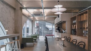 A modern interior with a long table, bar stools, and a bar area with shelves. - Hotel at gangnam seoul (Seoul)