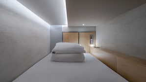 A minimalist hotel room with a bed, wooden paneling, and a view of the city. - Hotel at gangnam seoul (Seoul)