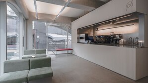 A modern interior with a reception desk, seating area, and a kitchenette. - Hotel at gangnam seoul (Seoul)