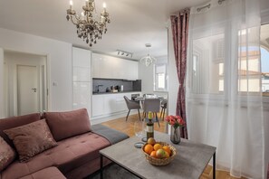 Un salon moderne avec un canapé, un coin repas et une cuisine en arrière-plan.