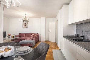 A modern kitchen with white cabinets, a black countertop, and a built-in sink. - Apt Ana Walk To Beach /w Balcony (Medulin)