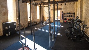 A gym with weightlifting equipment, a bench, and a bicycle. - Spacious 6-bedroom house in  Varennes, pool, 3 outdoor spaces, full gym, bikes. (Varennes)