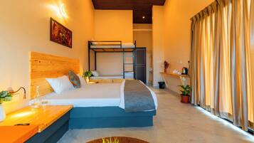 A bedroom with a bunk bed, bedside table, lamp, and a view of the hallway.