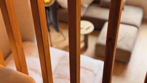 Een kamer met een houten stoel, een bank en een kleine ronde tafel.