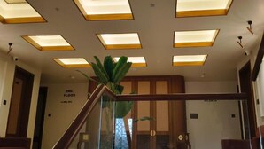 Ein modernes Interieur mit einer Treppe, einer Pflanze und einem Schild, das die 2. Etage angibt.