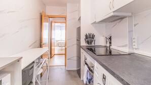 Cocina compacta con mostrador, pileta y vista al dormitorio contiguo.