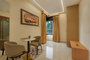 Una sala de estar moderna con comedor, un amplio ventanal con cortinas y un cuadro en la pared.