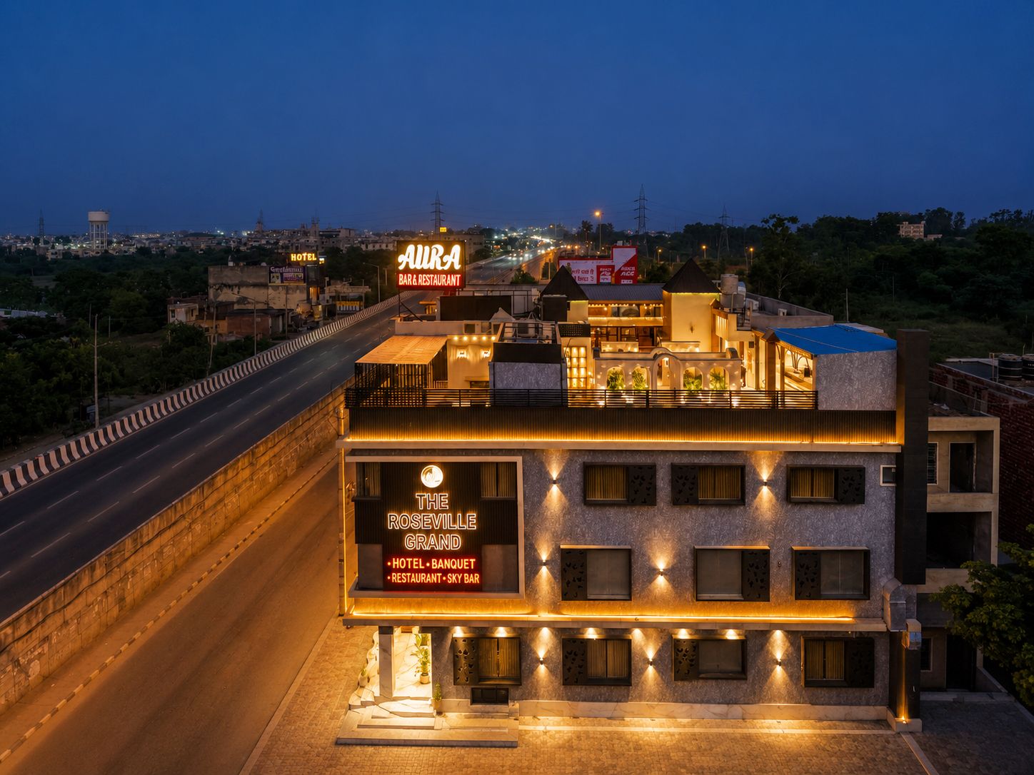 A hotel with a prominent sign for 'The Roseville Grand Hotel - Banquet - Restaurant - Sky Bar' and a visible 'AURA BAR & RESTAURANT' sign.