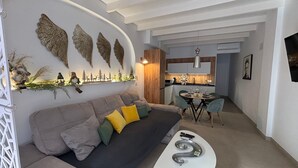 Ein modernes Wohnzimmer mit einer Couch, einem Couchtisch und einem Essbereich mit Stühlen.