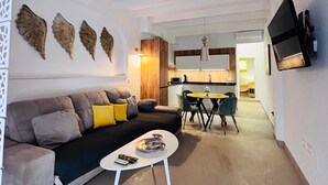 Ein modernes Wohnzimmer mit einer Couch, einem Couchtisch und einem Essbereich mit Stühlen und einem Tisch.