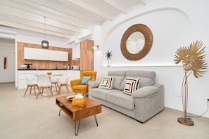 Ein modernes Wohnzimmer mit Sofa, Couchtisch und Essbereich.