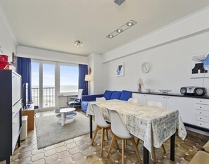 Eine moderne Küche mit Esstisch, Stühlen und Blick ins Freie.