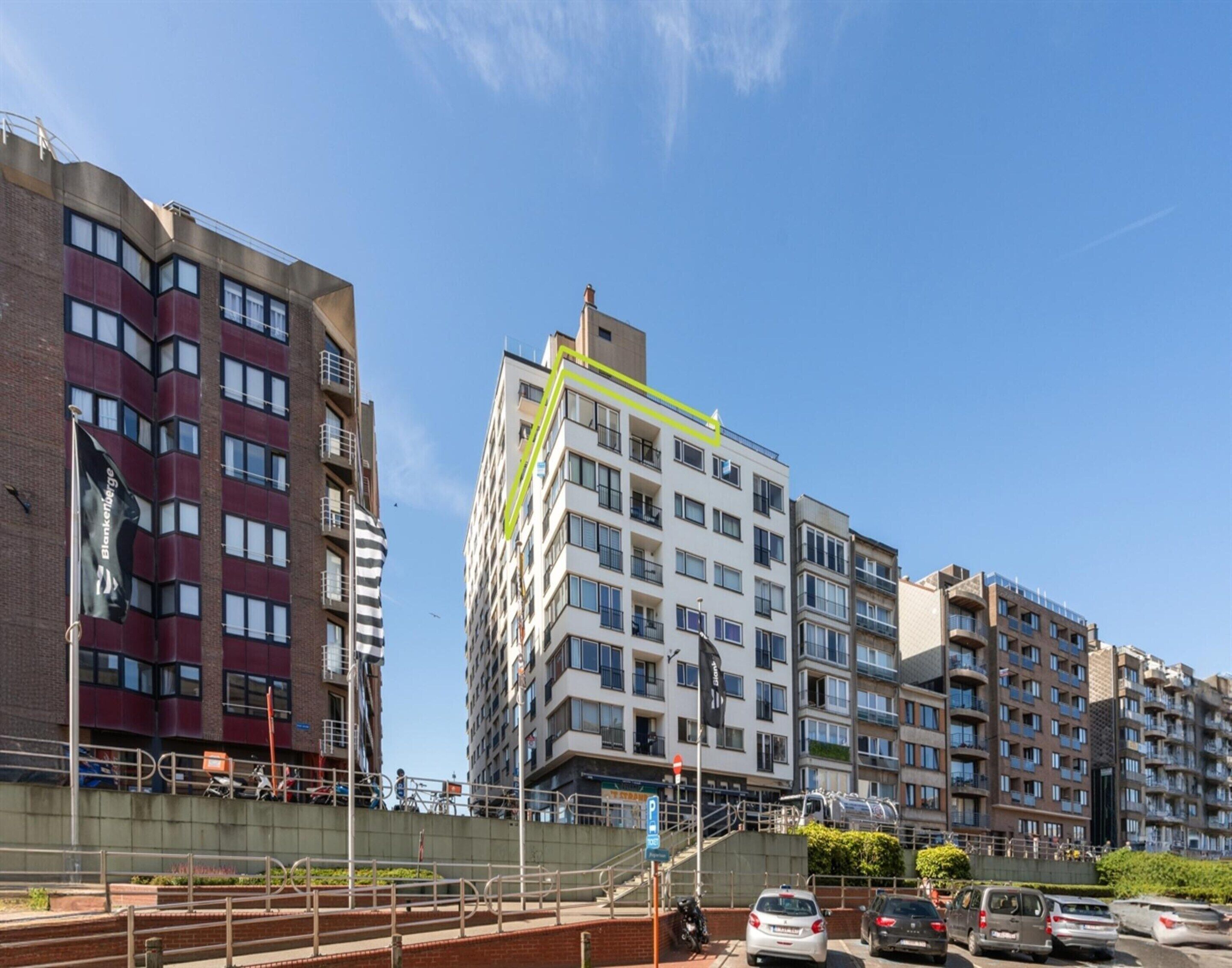A multi-story building with a modern architectural design, featuring balconies and a mix of window styles.