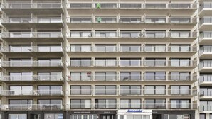 Un edificio de varios pisos con balcones, un restaurante llamado 'Bistro Den Engel' y un letrero que dice 'Zeesicht'.
