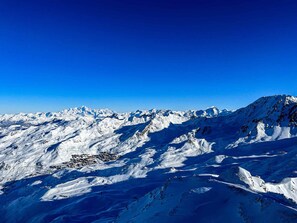 A snow-covered mountain range with a town nestled in the valley. - Apartment Near Centre of Orelle (Orelle)