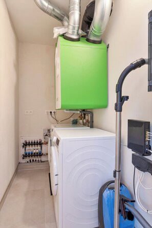 A laundry room with a washing machine, a dryer, and a water heater. - Apartment in Blankenberge Near the Beach (Blankenberge)