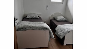 Une chambre avec deux lits, une fenêtre et un appareil de climatisation.