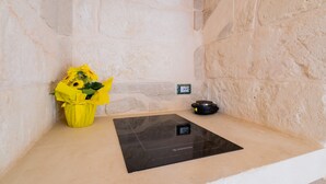 A stone wall, a black heated floor mat, and a yellow flower arrangement.