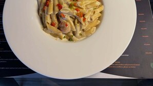 Un menú con varios platos, incluyendo pasta, sopa y un plato empanizado.