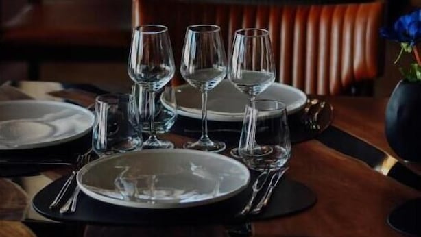 Ein Restaurant mit gedeckten Tischen, einschließlich Teller, Gläsern und Besteck.