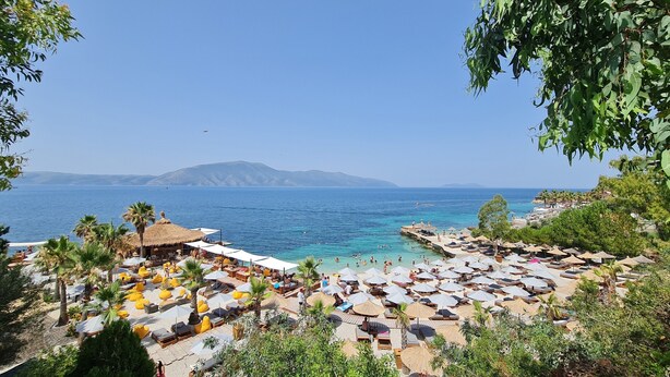 A beach resort with sun loungers, umbrellas, and a view of the sea. - Halina (Orikum)