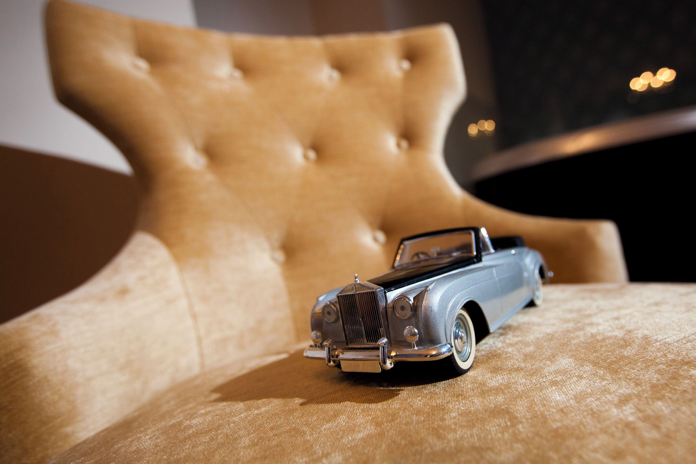 A model car on a tufted chair.
