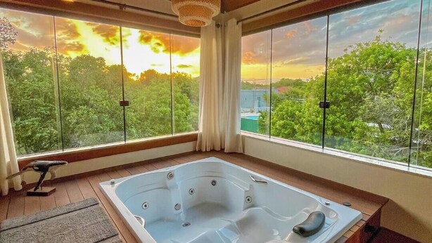 Une pièce dotée d’une grande fenêtre, d’un plafond en bois et d’un jacuzzi.