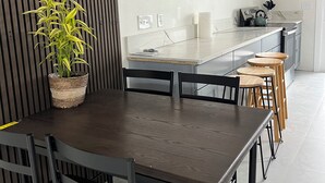 A modern kitchen with a dining area, featuring a wooden table, chairs, and a potted plant. - Spacious 4-bedroom , newly building in center of Hilo. (Hilo)
