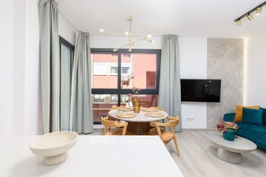 A modern dining area with a round table, chairs, and a vase of flowers. - Perchel - Holiday apartment Malaga City (Málaga)