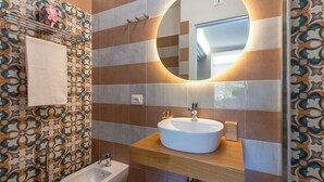 A bathroom with a sink, mirror, and bidet.