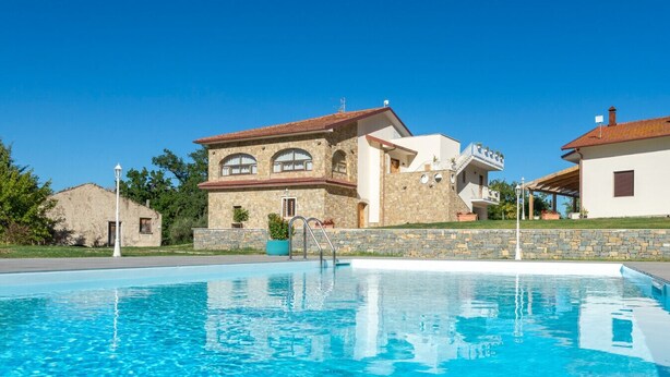 A swimming pool with a stone building in the background.