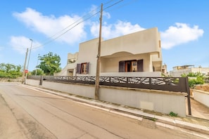 A modern two-story house with a flat roof, a gated entrance, and a street view. - Tenuta Marrocco House (Cursi)