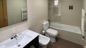 A modern bathroom with a bathtub, toilet, and sink. - 1 Standard with Patio. New apartment with the best views of Salamanca. (Salamanca)