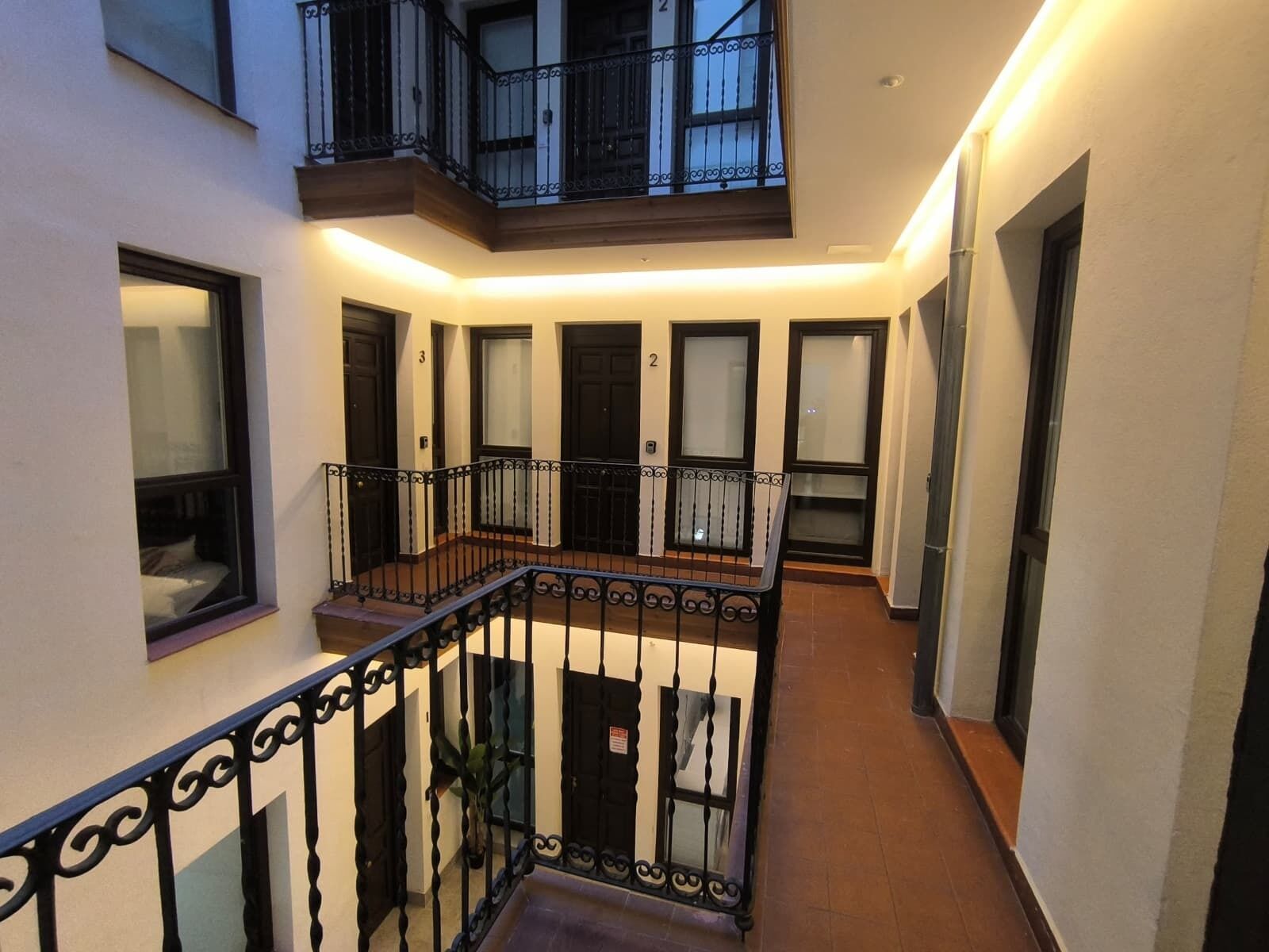 A multi-level residential building with a central staircase, balconies, and doors numbered 2 and 3.
