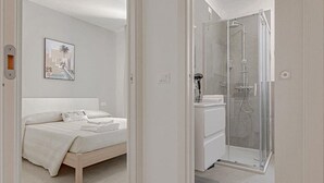 Un dormitorio con cama, ducha y baño.