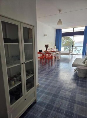 A room with a dining area, a sofa, and a view of the outdoors. - Sea view apartment in Castro with panoramic terrace and central location (Castro)