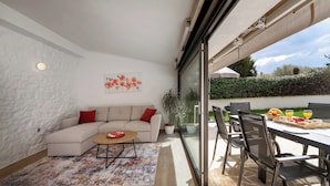 A modern living room with a sofa, coffee table, and a dining area with chairs and a table. - Casa Lampadina with pool  for 4-6 persons, located near Porec. Pets are welcome. (Vižinada)